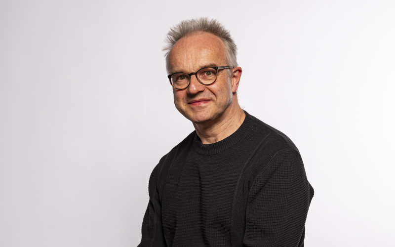 sitzender mann mit Hemd und Brille